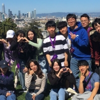 International students at Dolores Park, with a cityscape behind them
