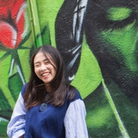 International student poses in front of Tupac mural